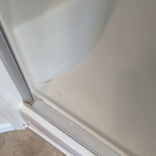 Shower door track cleaned to the metal